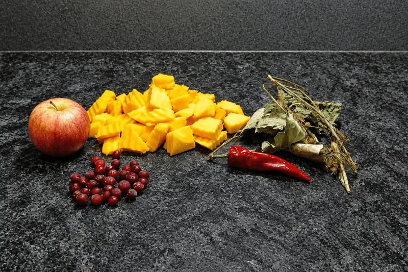 Ингредиенты для квашения тыквы — кусочки тыквы, листья вишни, дуба и хрена, клюква, перец чили и яблоко